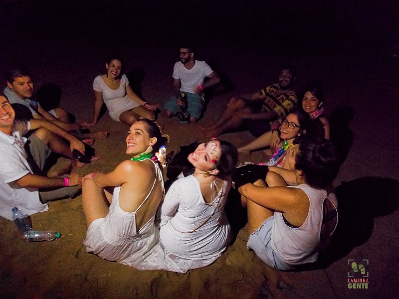 foto-de-pessoas-sentadas-reunidas-na-areia-do-mar