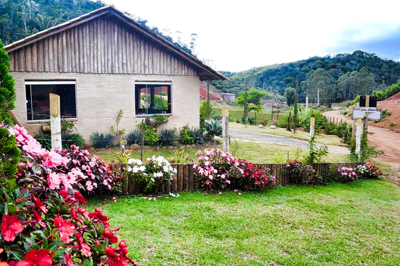 foto-demonstra-parte-externa-do-restaurante-comdiversas-flores-colorida-e-um-trecho-da-estrada-de-chão-batido-bem-conservada