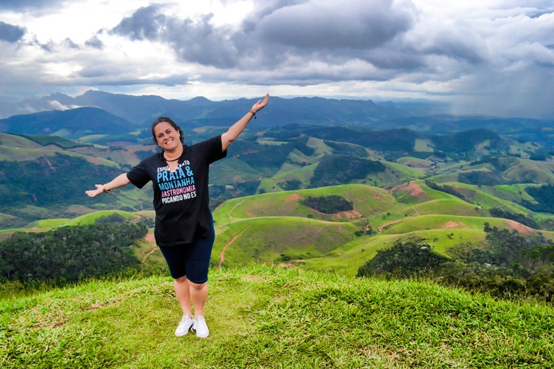 foto-mostra-pessoa-sendo-fotografada-com-diversas-cadeias-de-montanhas-ao-fundo