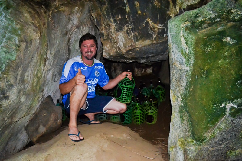 foto-mostra-homem-dentro-de-caverna-acompanhado-de-diversos-toneis-de-cachaça
