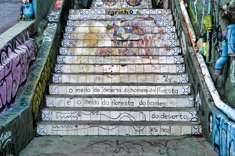 foto-mostra-a-escadaria-do-pátio-com-suas-frases-e-desenhos-coloridos-beco-do-batmam-uma-galeria-de-arte-a-ceu-aberto-na-vila-madalena