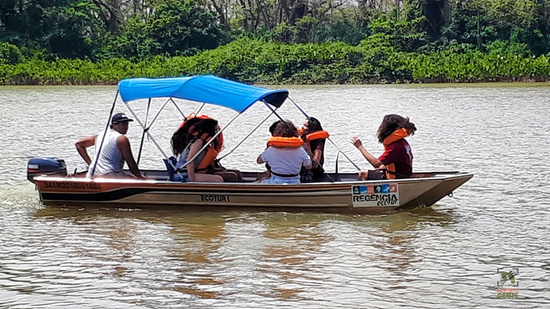 foto-mostra-barco-a-motor-com-pessoas-navegando-nas-aguas-do-rio-doce-em-regência-linhares-es