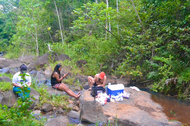 foto-mostra-pessoas-cozinhando-em-cima-de-pedra-em-meio-ao-rio.