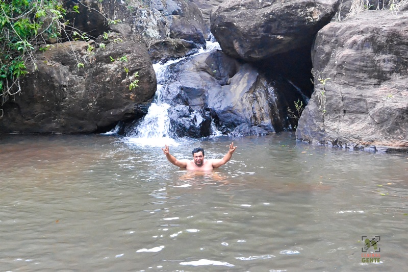 foto-mostra-pequena-queda-de-agua-e-pessoa-se-banhando