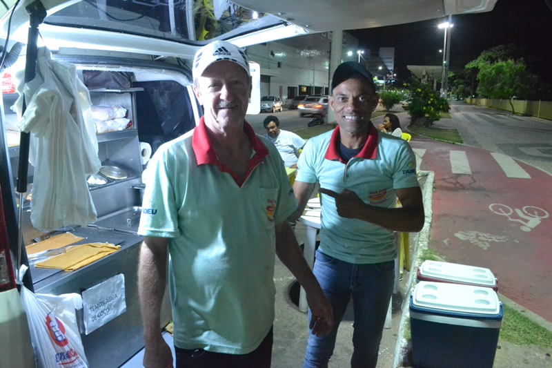 foto-mostra-duas-pessoas-em-frente-a-carrinho-de-cachorro-quente