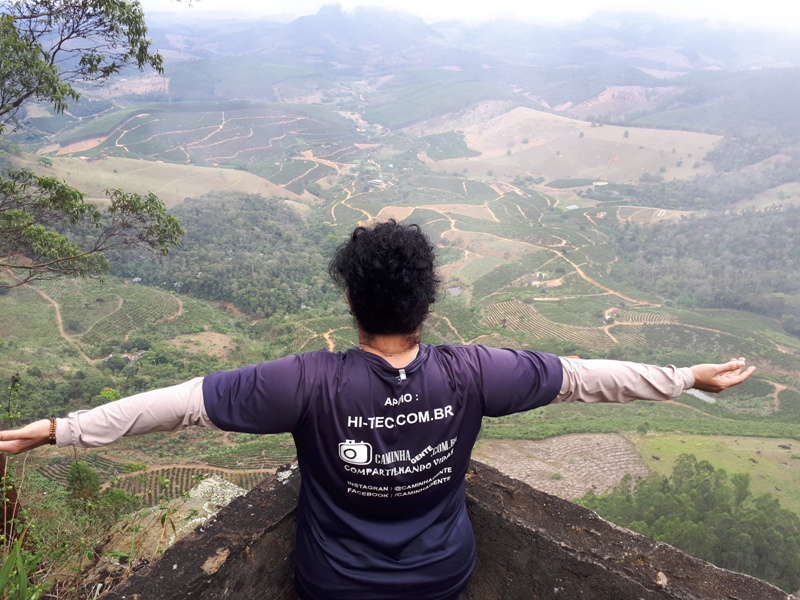 foto-mostra-pessoa-de-braços=-abertos-a-beira-de-um-muro-no-mirante-de-são-pedro-frio-em-colatina-es